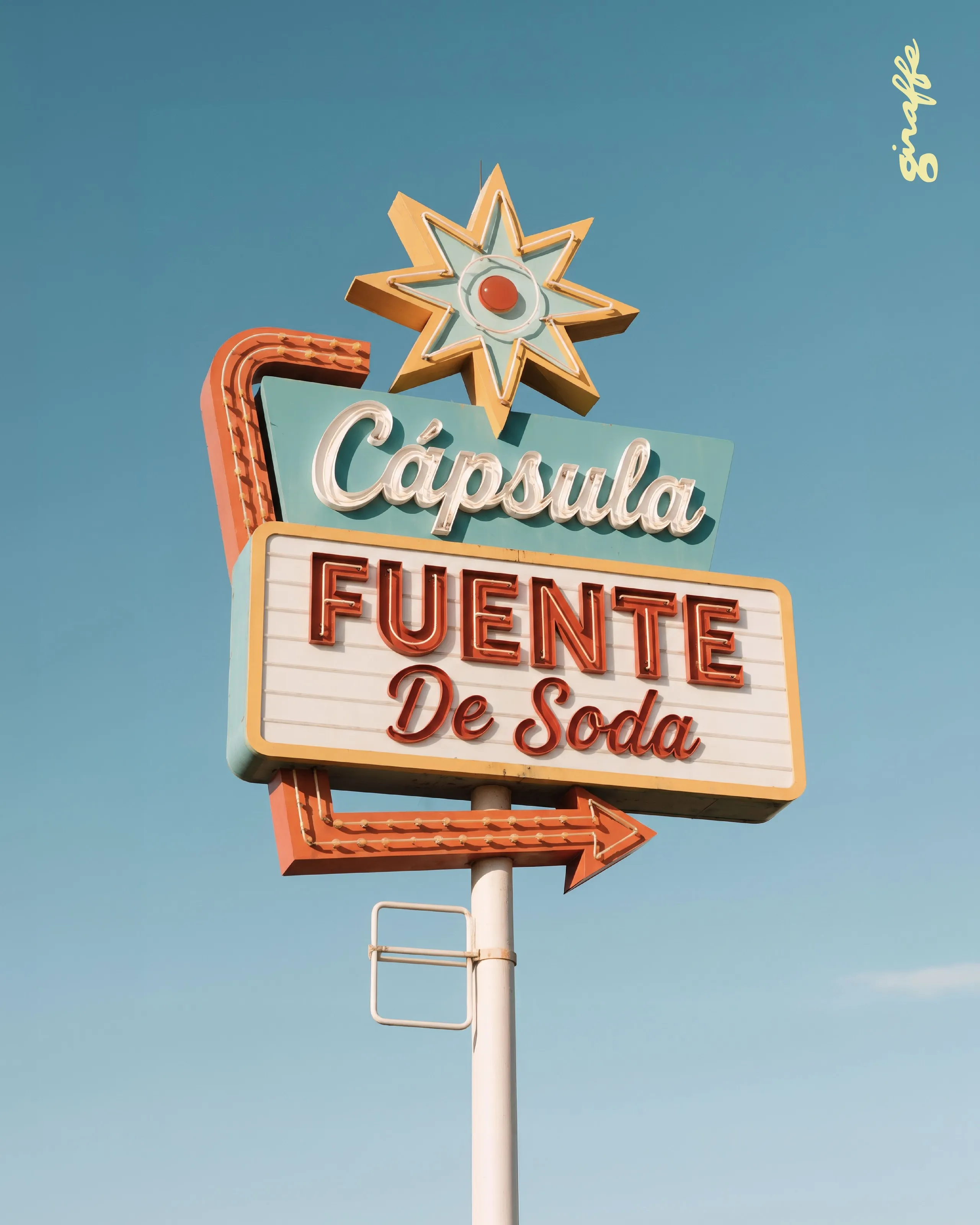 Letrero retro que dice Cápsula Fuente de Soda contra el cielo azul, primera lámina del carrusel