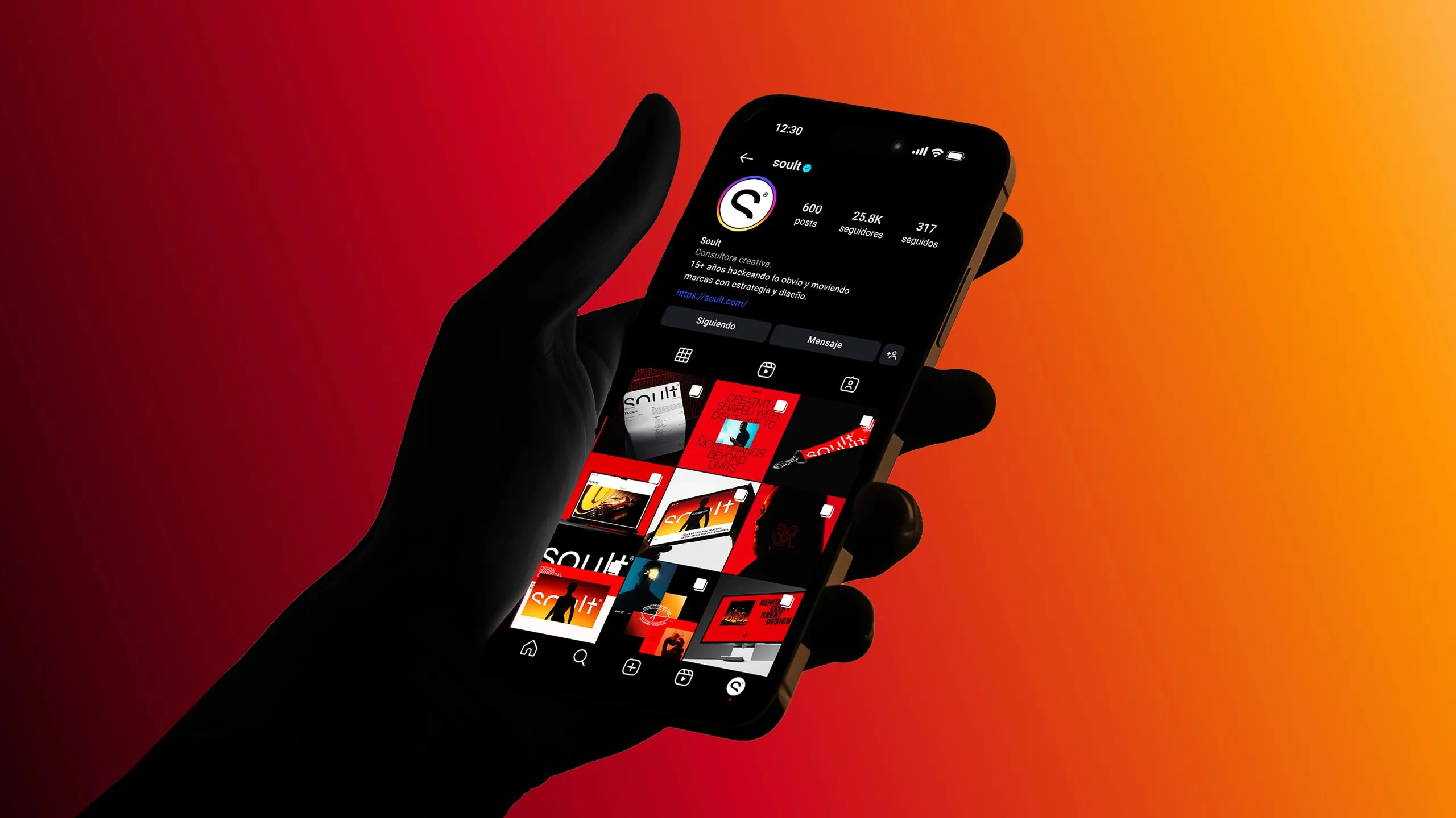 Mano sosteniendo un celular con el perfil de Soult sobre el degradado naranja y rojo