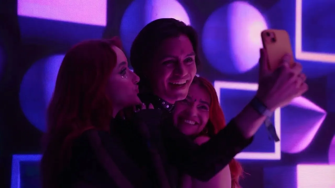 Asistentes del Festival BAUM se toman una foto entre luces violeta en la experiencia de HBO Max